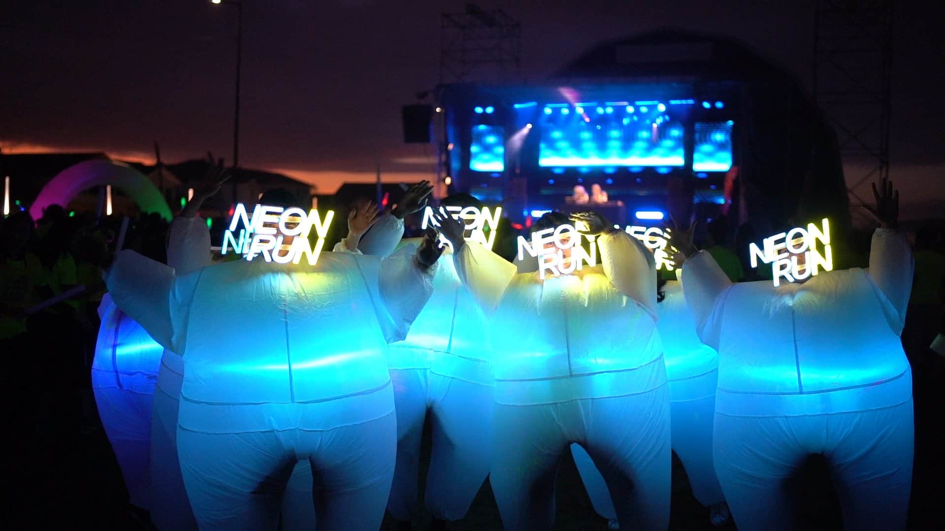 As mascotes da Neon Run com as máscaras vestidas